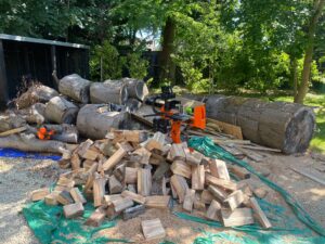 Log splitting service photo of our log splitting machine on site with split firewood